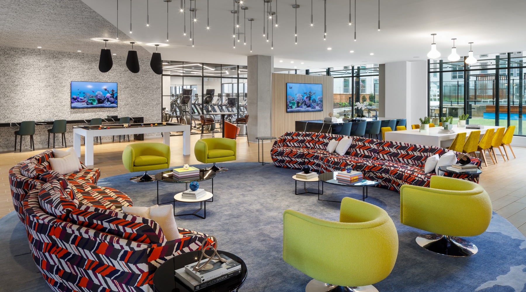 Relax and unwind poolside a room with a pool table and chairs and a large chandelier